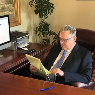 Stephen B. Morris sitting at his desk looking at legal pad